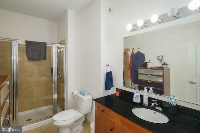 bathroom featuring tile patterned flooring, vanity, toilet, and an enclosed shower