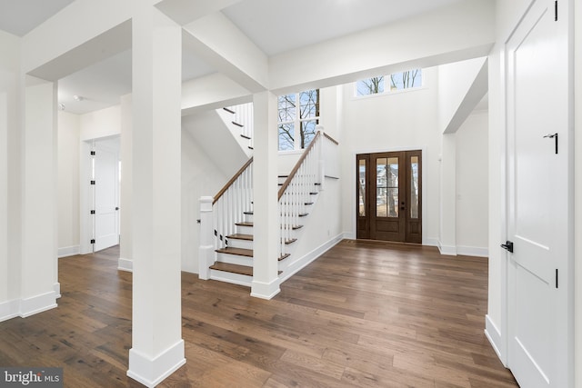 foyer entrance featuring dark hardwood / wood-style flooring and a towering ceiling