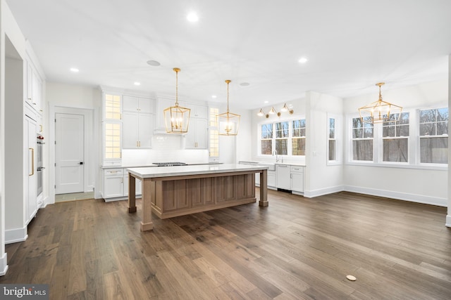 kitchen featuring a kitchen island, dark hardwood / wood-style flooring, and white cabinetry