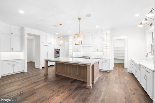 kitchen with decorative light fixtures, dark hardwood / wood-style floors, and white cabinetry