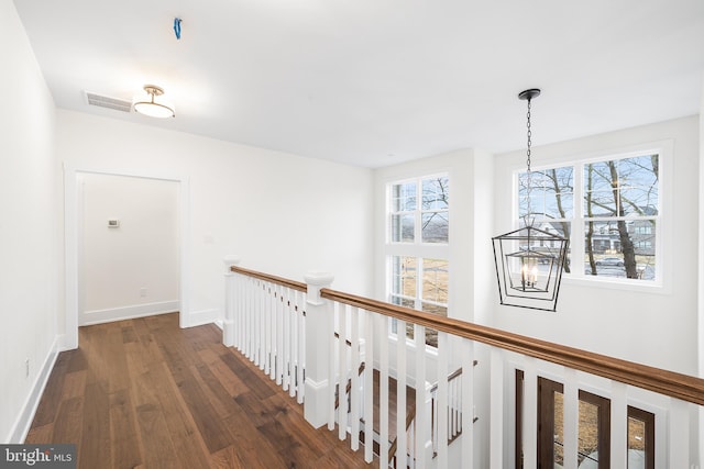 hallway featuring an inviting chandelier and dark hardwood / wood-style floors