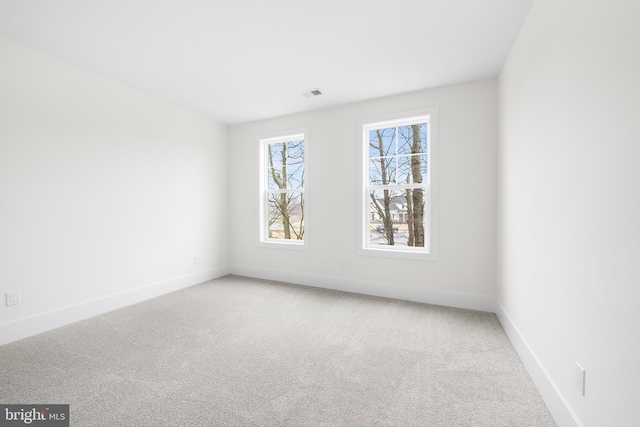 unfurnished room featuring light carpet