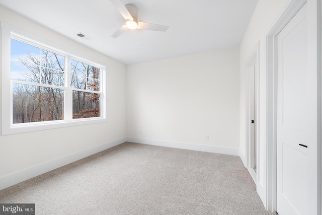 carpeted spare room featuring ceiling fan