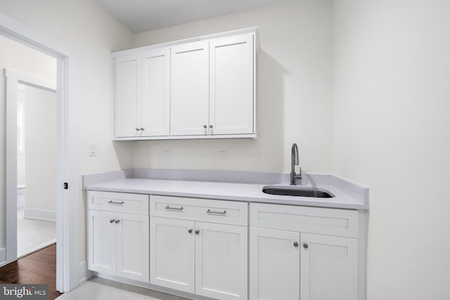 kitchen with white cabinets, sink, and light hardwood / wood-style floors