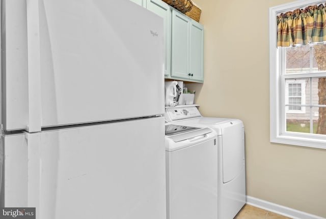 washroom with cabinets, light tile floors, and washer and clothes dryer