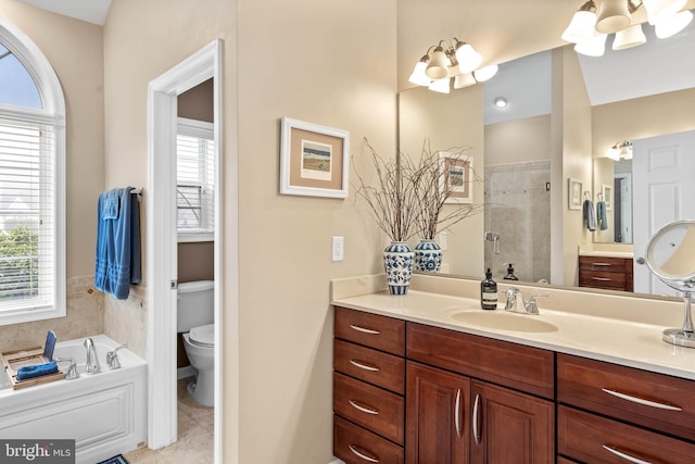 bathroom featuring vanity, a tub, a notable chandelier, tile flooring, and toilet