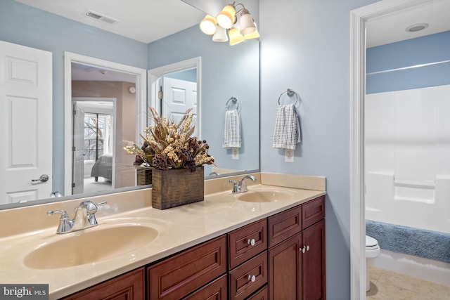 bathroom with tile floors, toilet, and dual bowl vanity