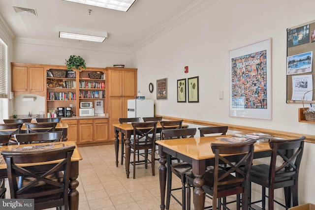 dining room with light tile floors and crown molding