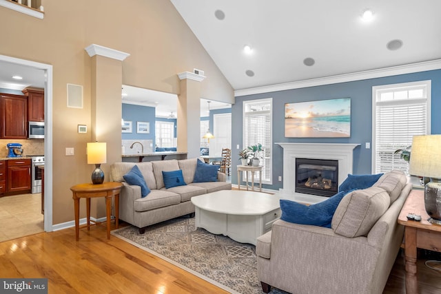 tiled living room with high vaulted ceiling and ornamental molding