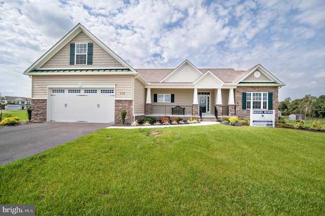 craftsman-style house with a garage, a front lawn, and covered porch