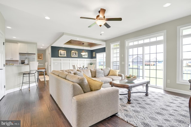 living room with ceiling fan, dark hardwood / wood-style floors, and a healthy amount of sunlight