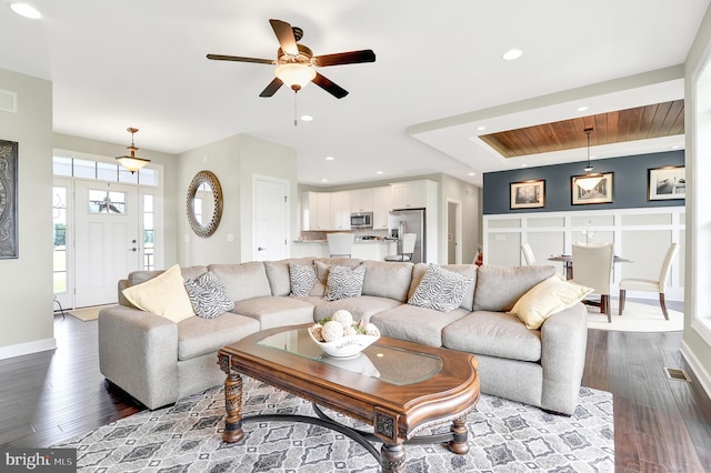 living room with ceiling fan and dark wood-type flooring