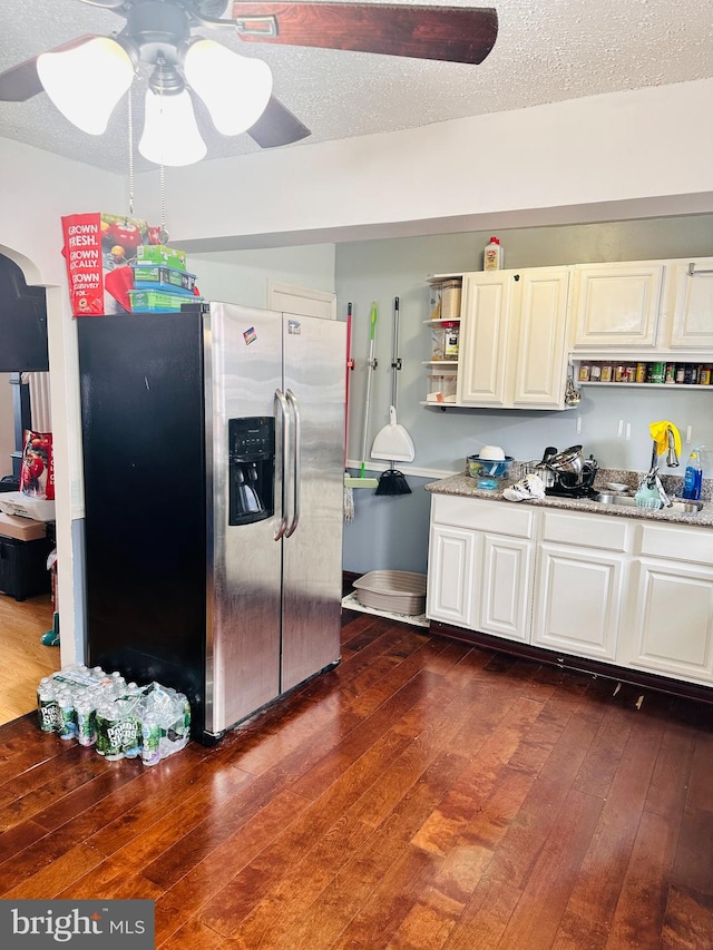 kitchen featuring stainless steel fridge, ceiling fan, a textured ceiling, light stone countertops, and dark hardwood / wood-style floors