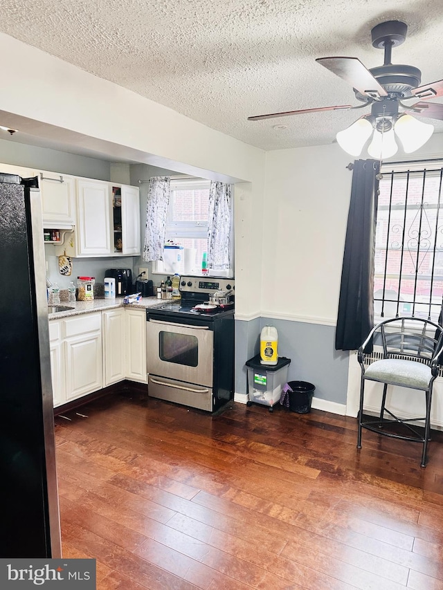 kitchen with black refrigerator, ceiling fan, white cabinetry, dark hardwood / wood-style floors, and electric stove