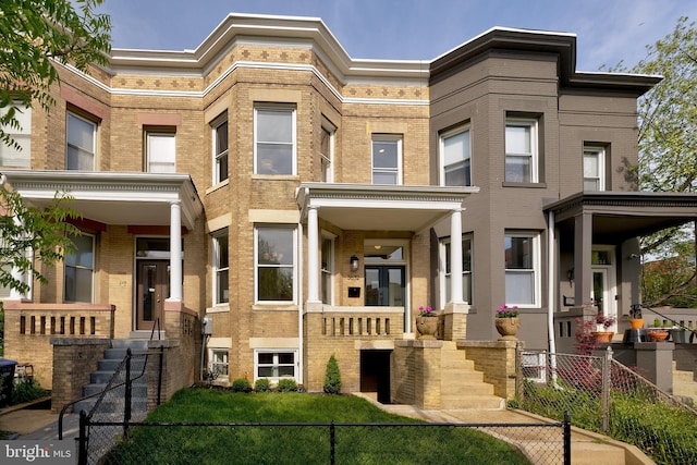 view of property featuring fence and brick siding