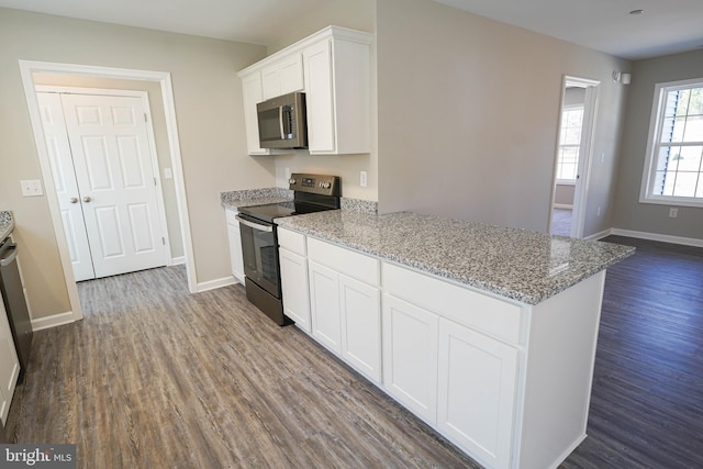 kitchen featuring white cabinetry, light stone countertops, electric range, and wood-type flooring