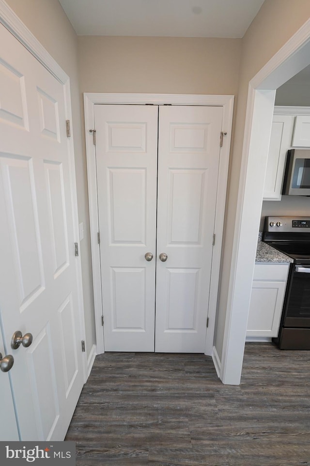 interior details with white cabinets, light stone countertops, dark wood-type flooring, and range with electric cooktop