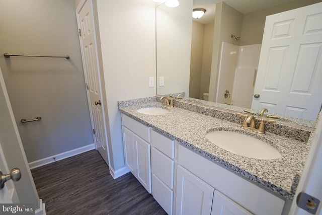 bathroom with hardwood / wood-style flooring, toilet, and dual bowl vanity