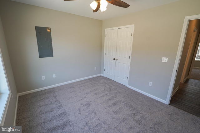 unfurnished bedroom featuring carpet, a closet, electric panel, and ceiling fan