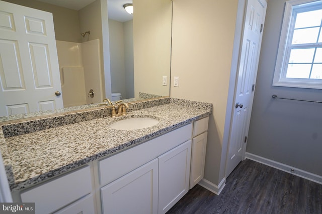 bathroom with toilet, hardwood / wood-style flooring, and vanity