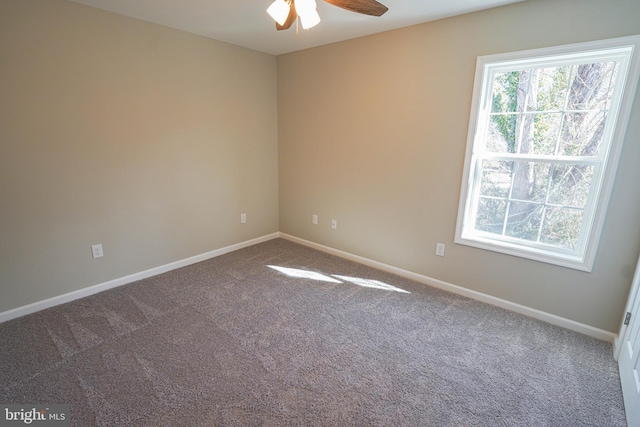 carpeted spare room featuring ceiling fan