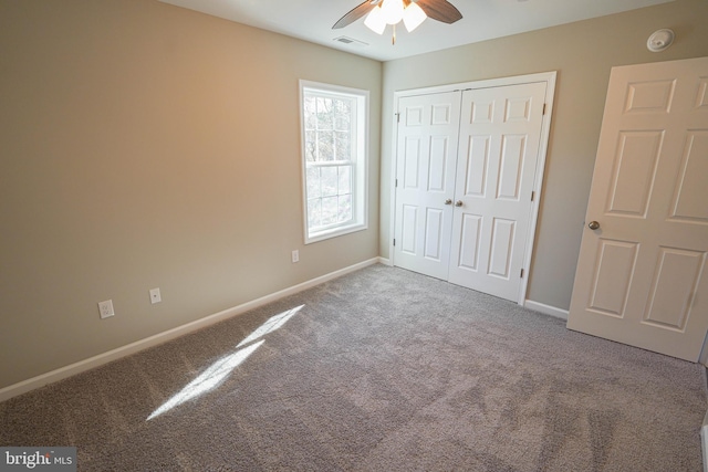 unfurnished bedroom with carpet floors, ceiling fan, and a closet