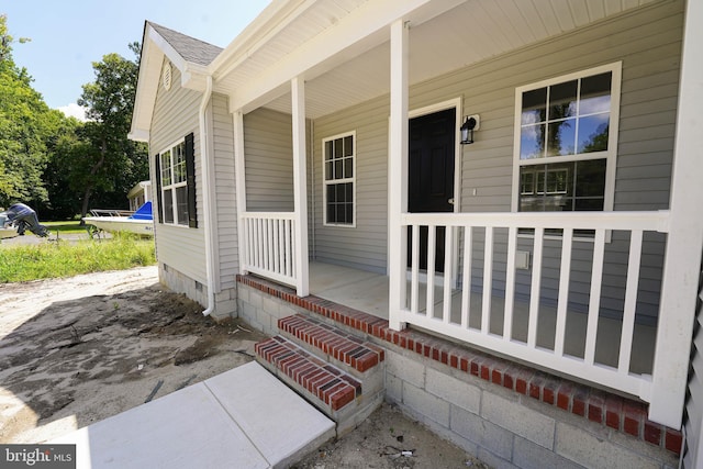 view of exterior entry featuring covered porch