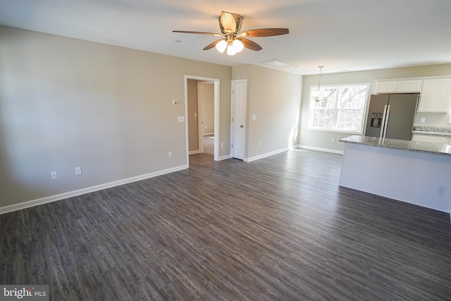 unfurnished living room featuring ceiling fan and dark wood-type flooring