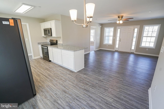 kitchen with hardwood / wood-style flooring, white cabinets, ceiling fan with notable chandelier, and stainless steel appliances