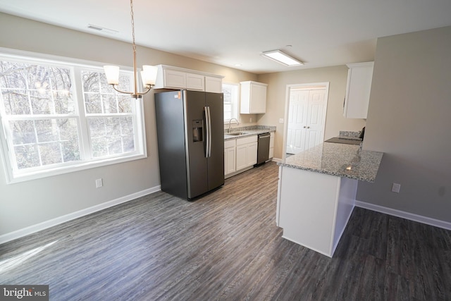 kitchen with appliances with stainless steel finishes, light stone counters, dark hardwood / wood-style floors, white cabinetry, and kitchen peninsula