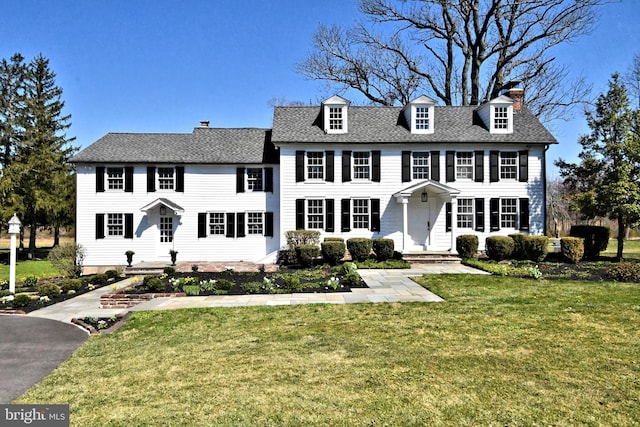 colonial home featuring a front yard