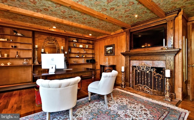 interior space with built in features, a tile fireplace, dark wood-type flooring, and beamed ceiling