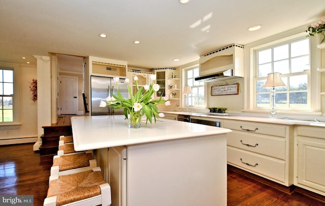 kitchen featuring a kitchen island, a kitchen bar, high quality fridge, a baseboard heating unit, and dark hardwood / wood-style floors