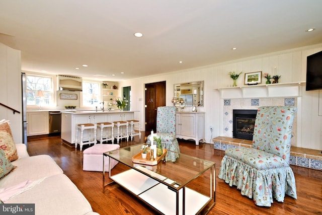 living room featuring dark hardwood / wood-style floors and a tiled fireplace