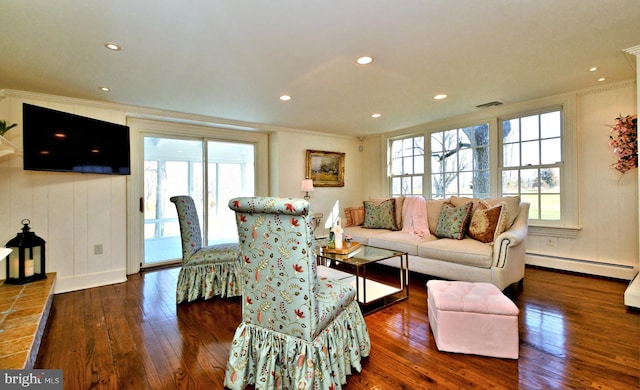 living room with dark hardwood / wood-style flooring, a baseboard heating unit, and ornamental molding