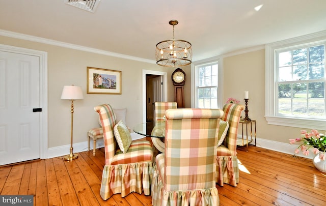 dining area featuring a notable chandelier, crown molding, and light wood-type flooring