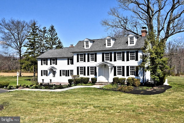 colonial-style house featuring a front yard