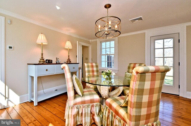 dining room featuring a chandelier, crown molding, a wealth of natural light, and light wood-type flooring