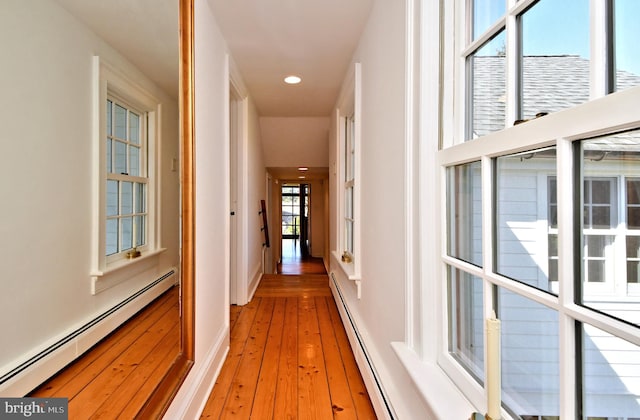 hallway featuring a baseboard heating unit and light hardwood / wood-style flooring