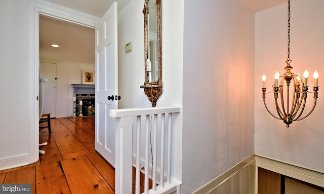 hallway featuring hardwood / wood-style flooring and a chandelier