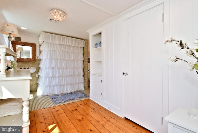 foyer entrance featuring ornamental molding and light hardwood / wood-style floors