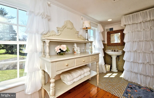 living area featuring ornamental molding, hardwood / wood-style floors, and a healthy amount of sunlight