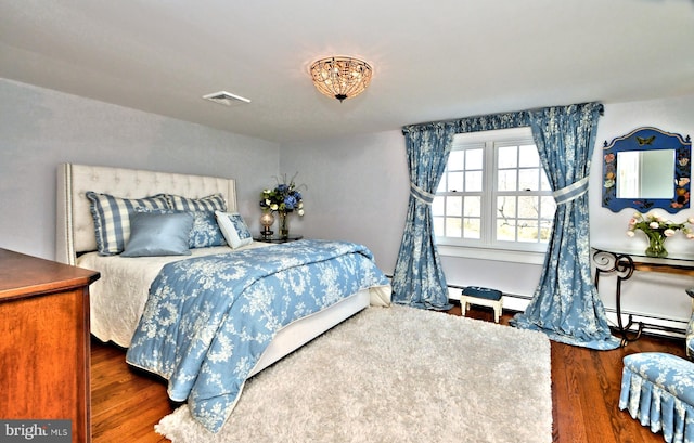 bedroom with a baseboard radiator and dark hardwood / wood-style floors