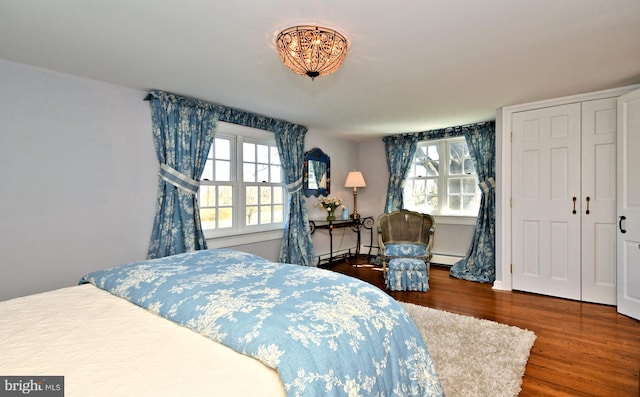 bedroom with a baseboard radiator and dark wood-type flooring