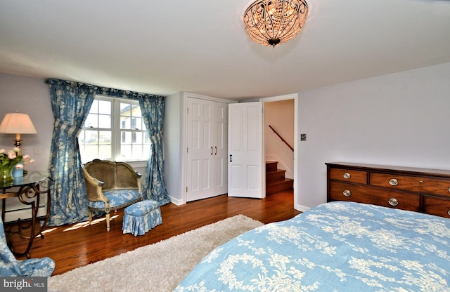 bedroom featuring dark hardwood / wood-style floors and a baseboard heating unit