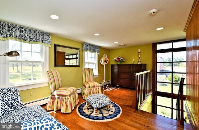 sitting room featuring baseboard heating, hardwood / wood-style floors, and plenty of natural light