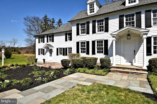 colonial inspired home featuring a front yard