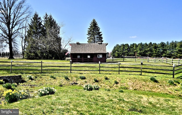 view of yard with a rural view and an outdoor structure