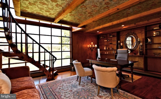 dining room featuring built in features, beamed ceiling, hardwood / wood-style floors, and a chandelier