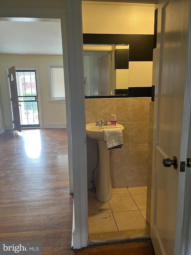 bathroom with wood-type flooring, tasteful backsplash, and tile walls